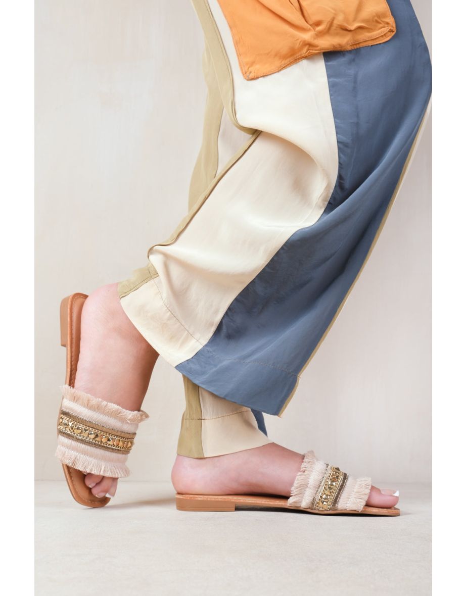 ASTROID FLAT SANDALS WITH FRINGE TRIM AND STUD DETAILS IN BEIGE