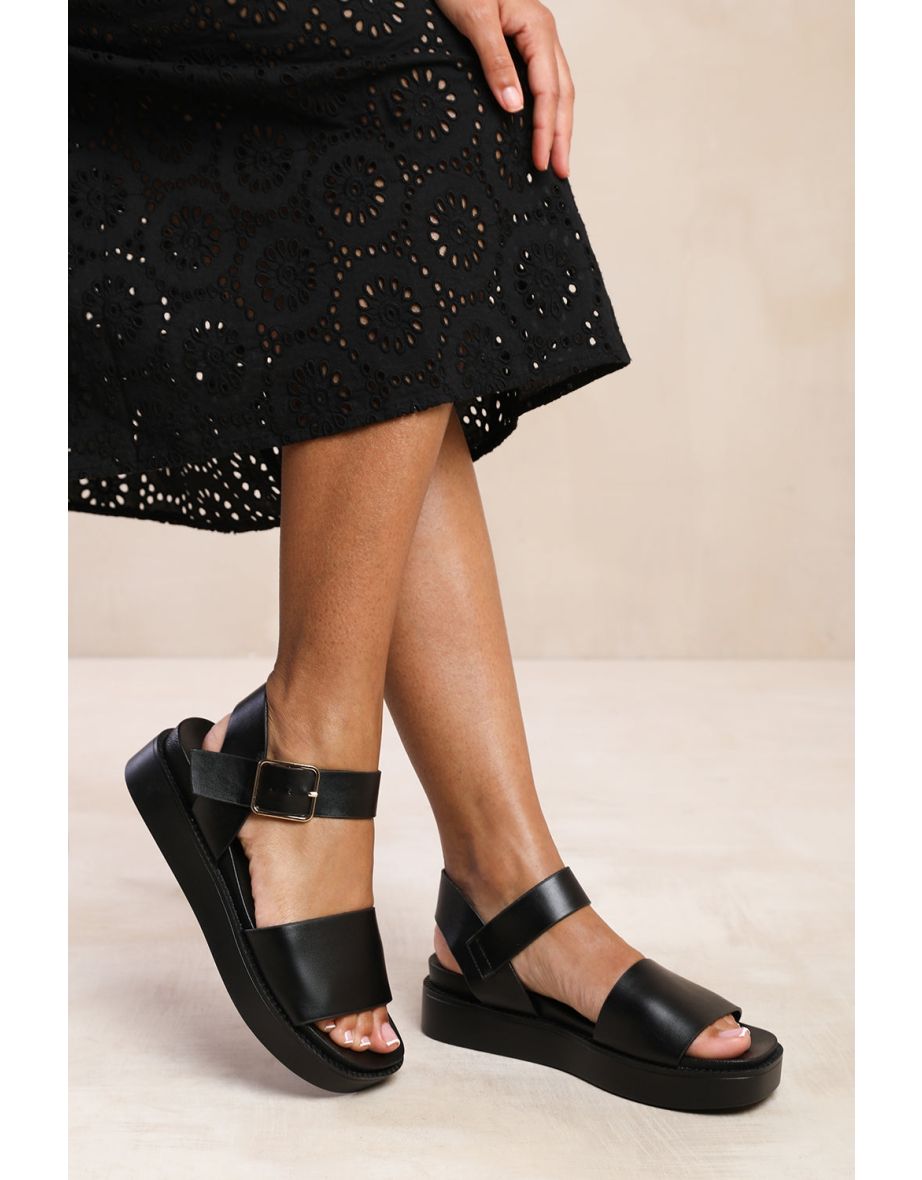 PHOENIX EXTRA WIDE FIT CLASSIC FLAT SANDALS WITH STRAP AND BUCKLE DETAIL IN BLACK FAUX LEATHER
